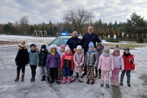 Zdjęcie przedstawia umundurowanych policjantów z grupą dzieci.