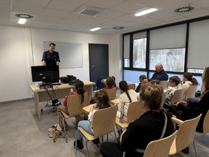 Zdjęcie przedstawia policjantów oraz dzieci podczas wizyty w sosnowieckiej komendzie.