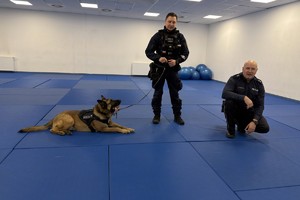 Zdjęcie przedstawia policjantów oraz psa służbowego.