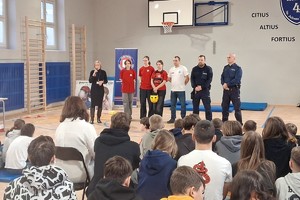 Zdjęcie przedstawia umundurowanych policjantów w sali gimnastycznej podczas spotkania.