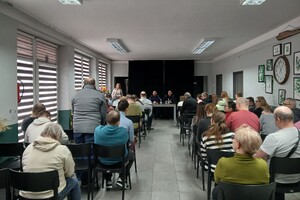 Zdjęcie przedstawia umundurowanych policjantów oraz uczestników spotkania w sali.