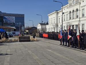 Zdjęcie przedstawia uczestników uroczystości na placu Dworca PKP.