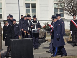Zdjęcie przedstawia uczestników uroczystości na placu Dworca PKP.