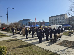 Zdjęcie przedstawia uczestników uroczystości na placu Dworca PKP.