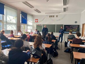 Zdjęcie przedstawia umundurowanych policjantów w sali lekcyjnej podczas prelekcji.