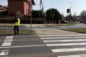 Zdjęcie przedstawia umundurowanego policjanta podczas czynności.