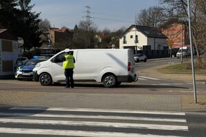Zdjęcie przedstawia umundurowanego policjanta podczas czynności.