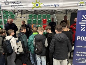 Umundurowany policjant podczas Dnia Bezpieczeństwa przy stoisku.