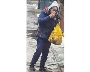 Mężczyzna w niebieskiej kurtce, w szarym kapturze z siatką koloru żółtego.