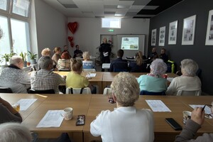 Umundurowany policjant podczas debaty przemawiający do uczestników spotkania.