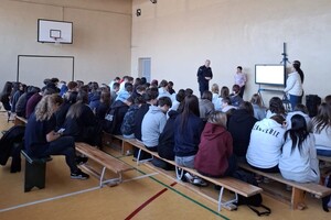 Dzielnicowy i pracownice MOPS-u w sali z uczniami.