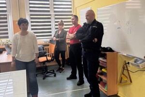 Policjant z pracownikami Miejskiego Ośrodka Pomocy Społecznej w klasie.