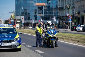 Zdjęcie przedstawia umundurowanych policjantów oraz radiowóz i motocykl policyjny