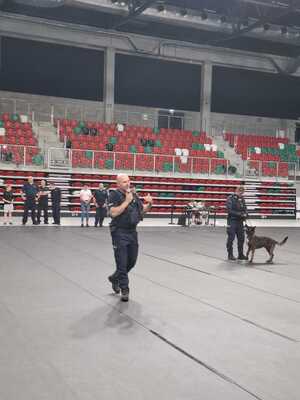 Zdjęcie przedstawia umundurowanych policjantów wraz z psem służbowym