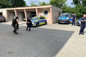 Policjanci, pies służbowy oraz dzieci.
