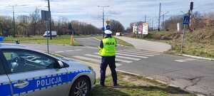 Umundurowany policjant wydziału ruchu drogowego podczas czynności.