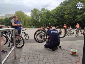 Policjant nanoszący grawer na rowerze.