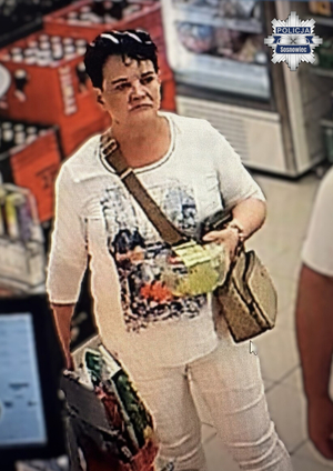 Kobieta z krótkimi, czarnymi włosami i białej bluzce na terenie sklepu.
