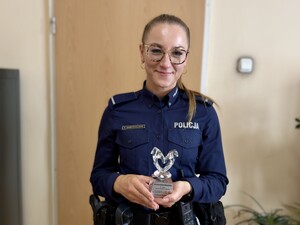 Umundurowana policjantka trzymająca statuetkę w rękach.